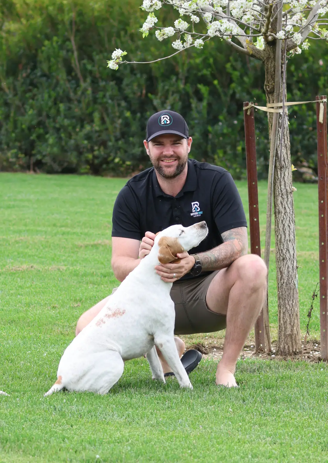 Dan White, founder of Buyers First Agency, with his dog in the backyard